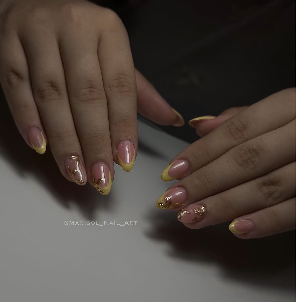 Uñas cortas rosas y amarillas con dorado